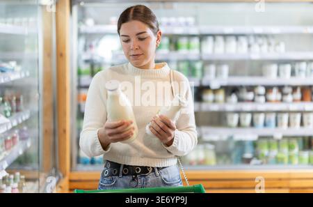 Frau wählt Milchprodukte Stockfoto