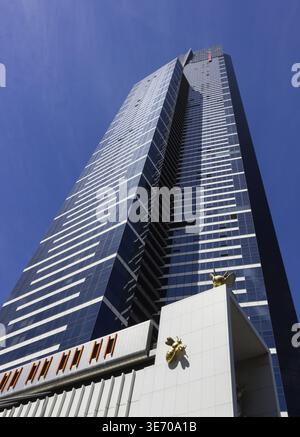 Blick von der Straße auf den Eureka Tower, einen hohen Wolkenkratzer in Melbourne, Australien, mit zwei großen Insektenskulpturen, die an der Seite des Gebäudes hochklettern Stockfoto