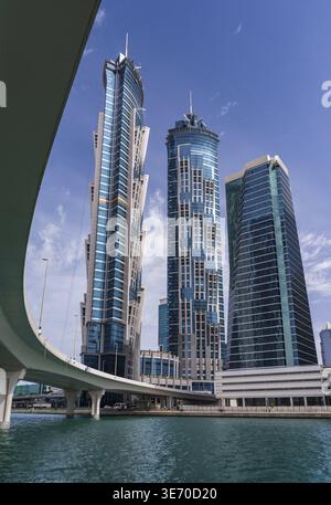 Neue Apartmentblöcke am Ufer und Radweg entlang des Dubai Canal mit Brücke Stockfoto
