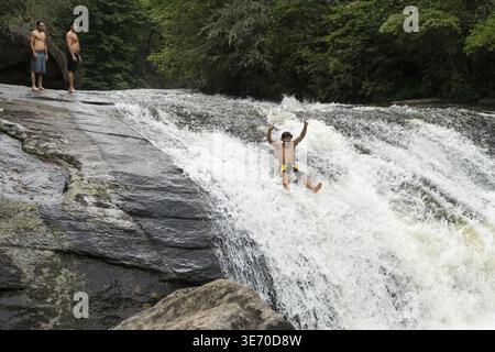Junge Erwachsene rutschen in den Turtleback Falls im Gorges State Park bei Cashiers in North Carolina, USA Stockfoto
