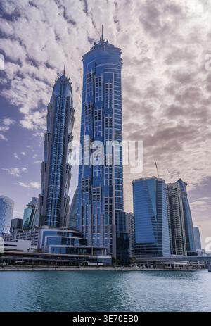 Neue Apartmentblöcke am Ufer und Radweg entlang des Dubai Canal mit dramatischem Himmel Stockfoto