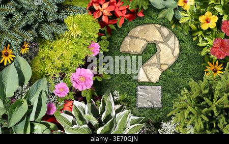Gartenfragen und Gartenberatung mit einem ornamentalen Gartenbeet- und Frühjahrsgartenkonzept, das als Fragezeichen mit einem gemähten Rasen geformt ist Stockfoto