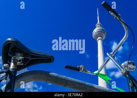 Oldtimer-Fahrrad vor dem Fernsehturm, symbolisiert nachhaltige Mobilität und umweltfreundlichen Verkehr in Berlin. Stockfoto