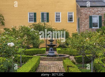 Kleiner Garten mit Backsteinpfaden und Wasserbrunnen im French Quarter von New Orleans Stockfoto