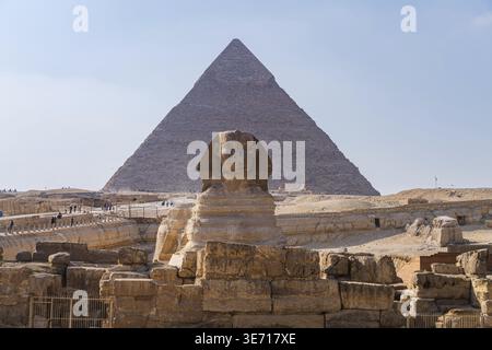 Pyramide von Khafre oder Chephren mit Verkleidung oben hinter der Sphinx mit Touristen, die umherwandern Stockfoto