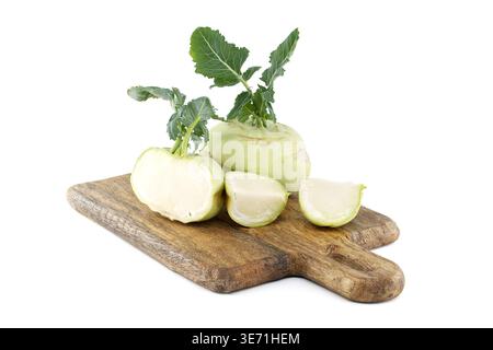 Frische grüne Kohlrabi-Zwiebeln und geschnittene Stücke auf einem rustikalen Holzschneidebrett angeordnet, isoliert auf weiß. Ideal für gesundes Kochen, Salate, Rezept p Stockfoto