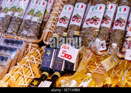 Venedig, Italien - 05. Dezember 2025: Italienische Gourmetgerichte, darunter Olivenöl, Kräuter und Gewürze, auf einem Markt wunderschön arrangiert Stockfoto