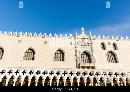 Venedig, Italien - 05. Dezember 2025: Dogenpalast in Venedig bietet atemberaubende venezianische gotische Architektur mit komplizierten Designs und einem hellblauen Himmel Stockfoto