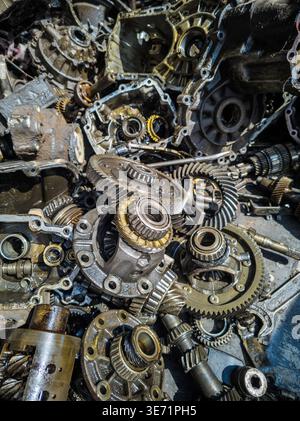 Nahaufnahme von durcheinander gerissenen Differenzial- und Getriebeteilen. Zahnräder, Lager und Schrauben erzeugen eine industrielle, körnige Atmosphäre mit öliger Textur Stockfoto
