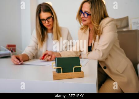 Zwei Geschäftsfrauen diskutieren Dokumente, arbeiten zusammen an einem Schreibtisch Stockfoto