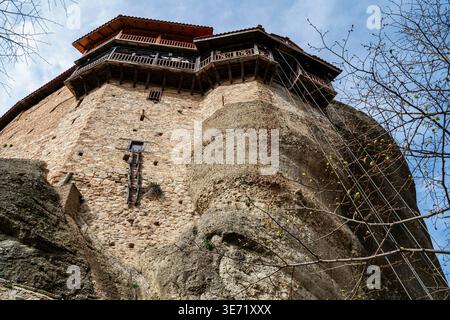Das Heilige Kloster des Heiligen Nikolaus Anapausas thront dramatisch auf einer schmalen Felssäule in Meteora, Griechenland. Bekannt für seine kompakte Architektur und Stockfoto