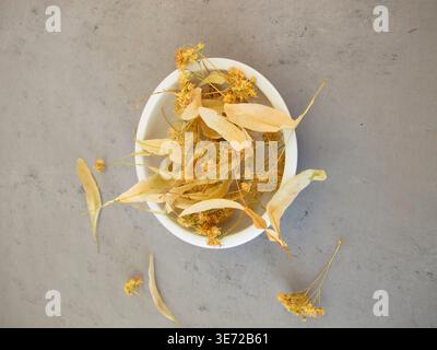 Getrocknete Limettenblüten zum Heilen von Limettenblütentee in einer Porzellanschale Stockfoto
