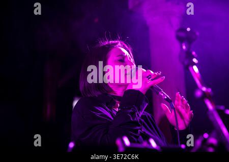 Weibliche Sängerin tritt live auf der Bühne mit rosa Beleuchtung auf. Stockfoto