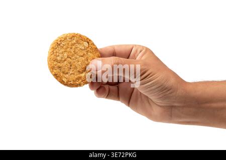 Männliche Hand, die Getreide-Weizen-Kekse isoliert auf weißem Hintergrund hält Stockfoto