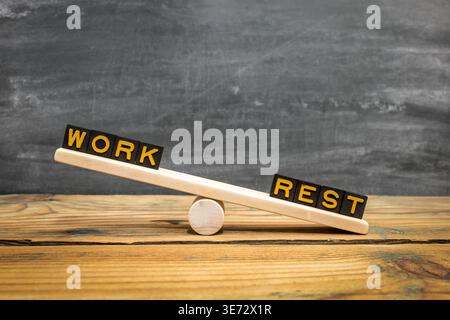Wooden Balance Zeigt Work And Rest Words Auf Wippe Über Tisch Hintergrund Stockfoto