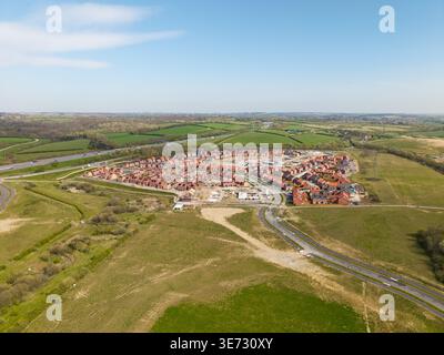 Aus der Vogelperspektive über einer neuen Wohnsiedlung mit erschwinglichen und umweltfreundlichen Häusern, die auf Grüngürtel gebaut werden. Neue Wohnsiedlung, um das Haus zu füllen Stockfoto