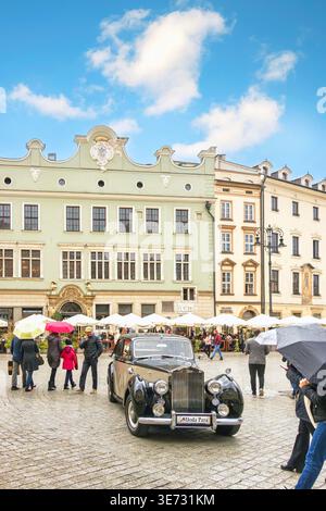 Klassischer schwarzer Rolls-Royce Silver Dawn-Oldtimer aus dem Jahr 1954, der auf dem Kopfsteinpflaster-Hauptmarkt in Krakau, Polen, mit historischer Architektur geparkt ist Stockfoto
