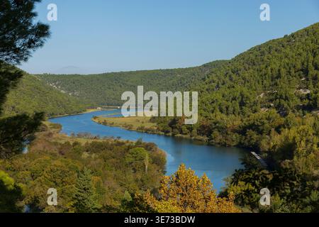 Blick auf den Fluss, der sich durch bewaldete Hügel schlängelt. Malerische Naturlandschaft von oben Stockfoto