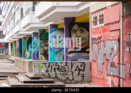 Street Art und Graffiti auf Säulen und Wänden eines Wohnbauprojekts in Berlin Stockfoto