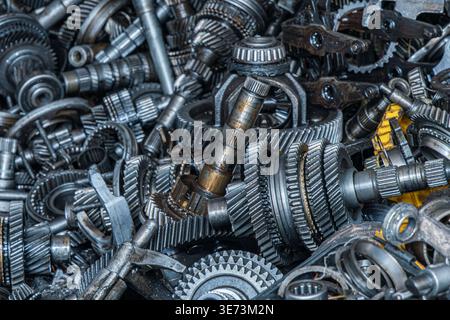Nahaufnahme erfasst einen dichten Haufen von verschiedenen Metallzahnrädern und mechanischen Komponenten. Texturen und Metallic-Glanz unterstreichen die industrielle Ästhetik. Stockfoto
