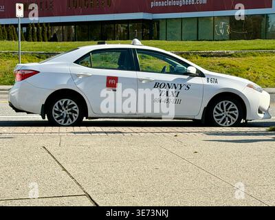 Burnaby, BC - 9. April 2026: Ein Seitenprofil eines weißen Bonny's Taxi Toyota Prius, der auf einer Stadtstraße in British Columbia, Kanada, parkte. Stockfoto