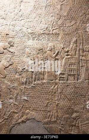 Antike assyrische Steinreliefschnitzerei von Figuren Stockfoto