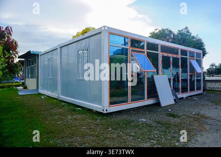 Modernes modulares Containergebäude mit Glasfenstern auf Gras Stockfoto