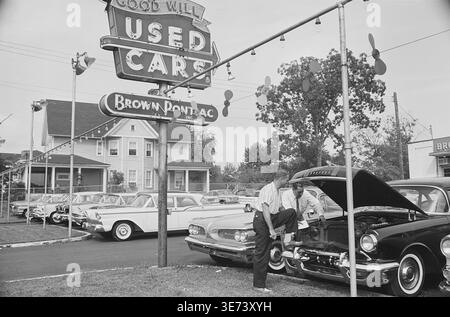 Historisches Bild von zwei Männern, die den Motor eines Autos unter einer offenen Motorhaube auf einem Braun Pontiac Gebrauchtwagenhändler in Arlington, Virginia, untersuchen, 31. August 1960. Foto von Warren K. Leffler. Stockfoto