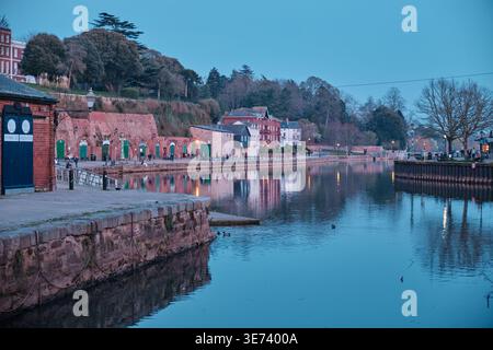 Exeter, Vereinigtes Königreich - 20. März 2026. Historische Sandsteinlager im Exeter Canal Basin schimmern in der Abenddämmerung im Fluss exe Stockfoto