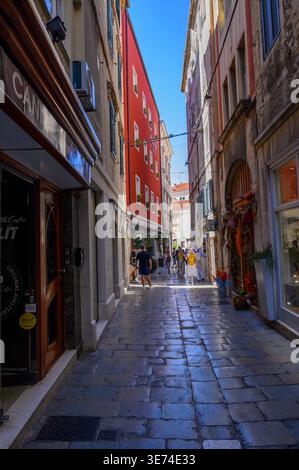 Eine enge Kopfsteinpflasterstraße zwischen alten Häusern mit Geschäften im Erdgeschoss außerhalb der Altstadt von Split in Kroatien. Stockfoto