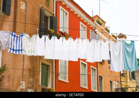 Kleidung trocknet auf einer Cothes Linie mit bunten Gebäuden im Hintergrund, Venedig, Italien Stockfoto