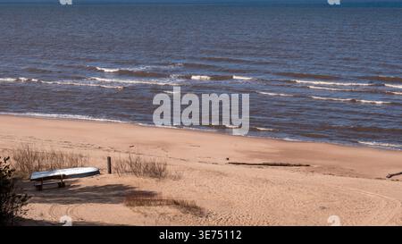 Leerer Ostseestrand im Frühjahr mit umgedrehtem Boot – Quiet Seaside Village Travel Concept Stockfoto