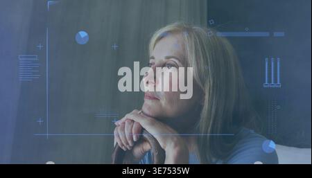 Eine Frau in blauer Spitze auf Holzstuhl im Schlafzimmer, liegendes Kinn, Blick nach rechts, Ring, HUD. Reif, weiblich, Sessel, Porträt, Diagramme, Diagramme, Daten Stockfoto