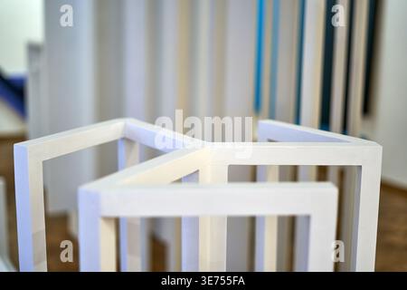 Eine Nahaufnahme eines minimalistischen weißen geometrischen Holzgebäudes mit klaren Linien und kantigen Ecken, die einen offenen Würfel oder ein Gitter bilden Stockfoto