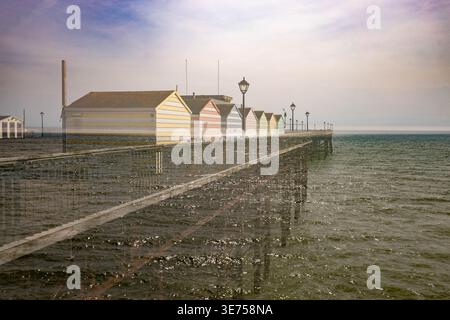 Doppelte Exposition mit Strandhütten und Pier Stockfoto