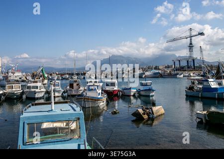Malerischer Blick auf den Fischerhafen Porticello in Sizilien, Italien, mit einer Mischung aus traditionellen Fischerbooten und kleinen Schiffen entlang einer lebhaften Küste Stockfoto