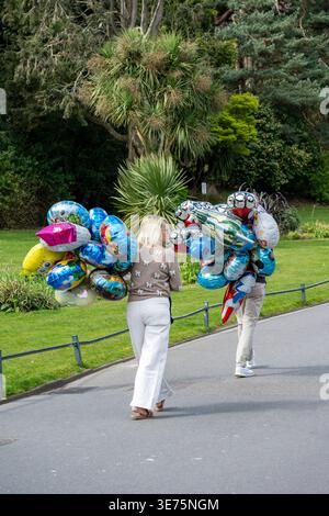 Zwei Ballonverkäufer in einem Park im Stadtzentrum von Bournemouth, Dorset, England, Großbritannien Stockfoto