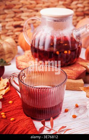 Gemütliches Herbstgetränk mit Sanddorn in Glasbecher Stockfoto