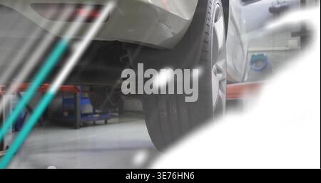 Zeigt die Montage des rechten Hinterrads und der Schraubenfeder an silbernem Auto in der Garage, mit rotem Hubarm Stockfoto