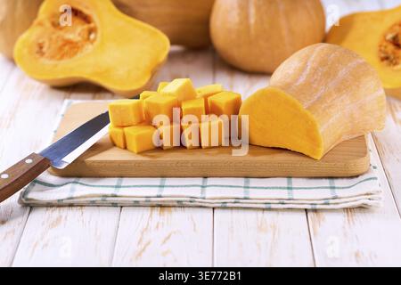 Gewürfelter Butternusskürbis auf hölzernem Schneidebrett Kopierraum für Text Stockfoto