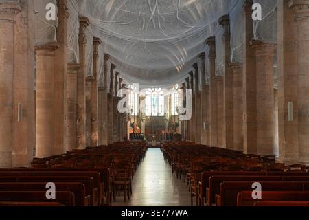 Innenansicht des Kirchenschiffs der Kathedrale Notre-Dame mit Holzbänken und Sicherheitsnetz unter der Decke, Le Havre, Frankreich Stockfoto