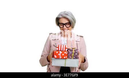 Seniorin hält viele bunte Geschenke und feiert Stockfoto