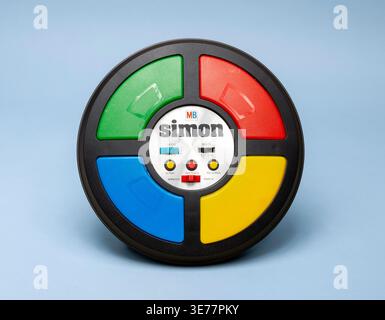 Pavia, Lombardei, Italien-30. März 2026: Klassisches Simon-Spiel mit Retro-Spielzeug und Technologie aus den 1980er Jahren auf blauem Hintergrund. Wird unter Strg+Alt M angezeigt Stockfoto