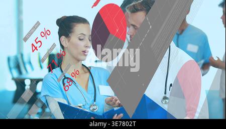 Die Krankenschwester in blauen Peelings mit blauem Clipboard-Briefing-Team mit Prozent-Grafiken erklären Stockfoto