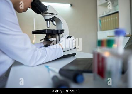 Nahaufnahme von jungen erwachsenen Laborarbeitern, die Proben mikroskopisch untersuchen, medizinische Forschung durchführen. Nützlich für Innovationen im Gesundheitswesen, Diagnostik und Biotechnologie-Marketing Stockfoto