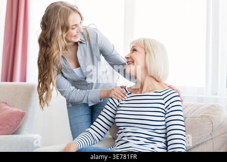 Positive Frau und ihre Tochter ruhen zu Hause aus Stockfoto