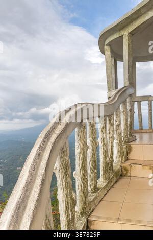 Blick vom Ambuluwawa Tower, einem multireligiösen Tempelkomplex in Gampola in Sri Lanka. Rustikale Betonbalustrade und Pavillontreppen mit Blick auf das Hotel Stockfoto