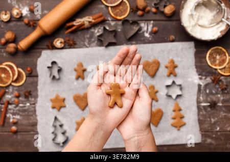 Frau, die rohen Weihnachtskeks über dem Tisch hält, Blick von oben Stockfoto
