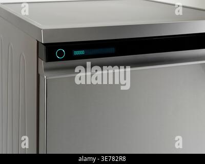 Spülmaschinenbedienfeld mit beleuchteter Taste, Nahaufnahme und modernem Edelstahl Stockfoto