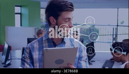 Lehrer in karierter Führung im Computerlabor mit Tablet, Monitoren und Netzwerkgrafik Stockfoto